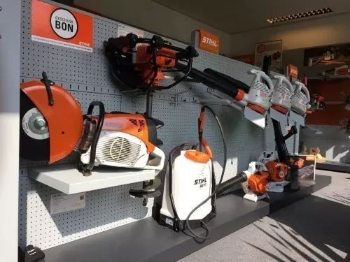 Stihl-machines en een rugspuit uitgestald aan een wand in de showroom